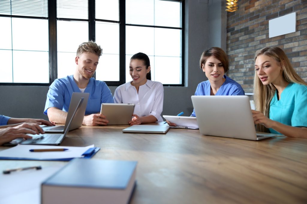 group of medical students studying together sitting at a large table
